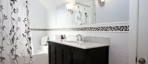 White bath with glass mosaic border